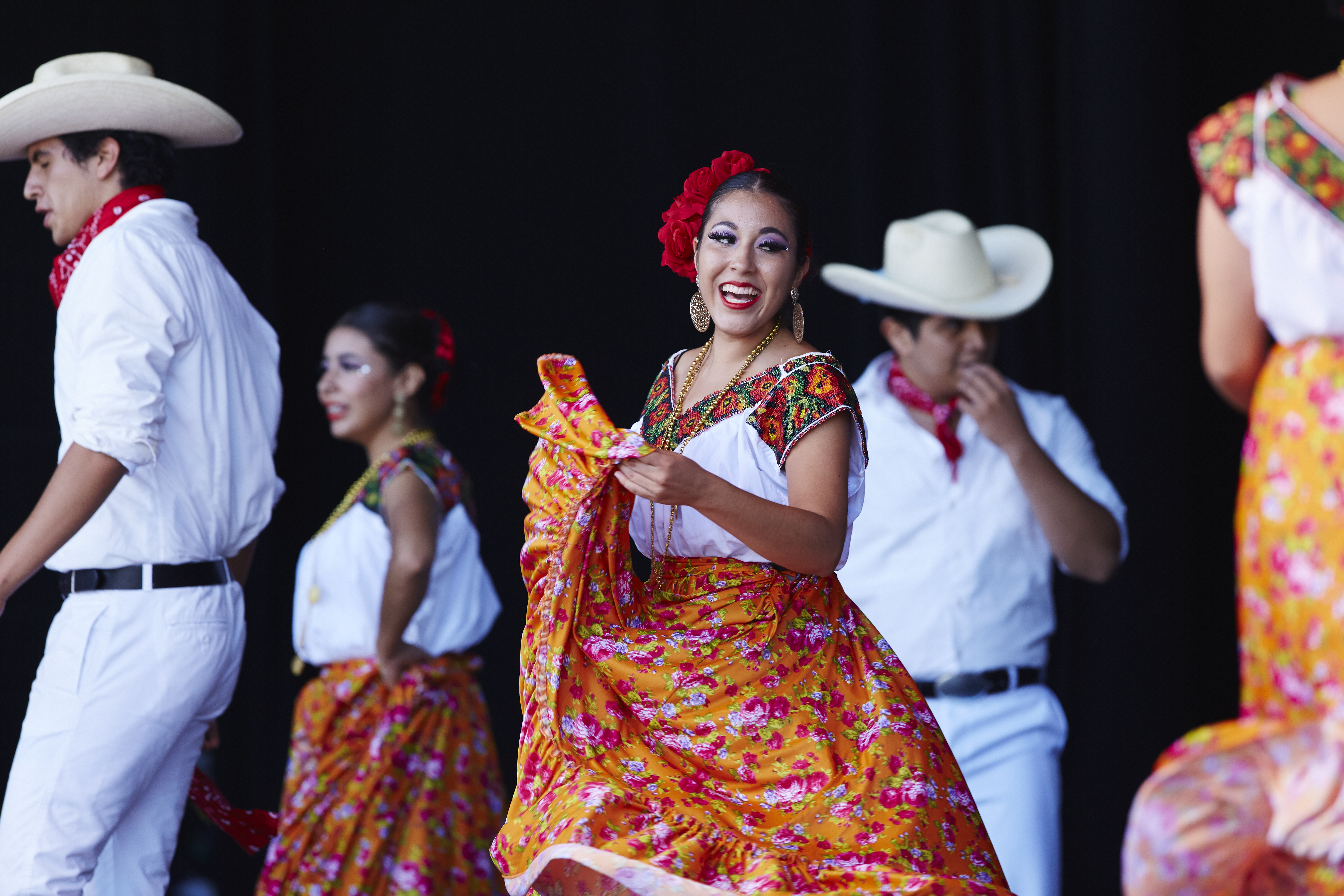 Hispanic woman smiling and dancing at a mexican fiesta